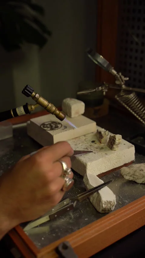 Hands of a young craftsman heating a precious stone with a blowtorch in a g.. Stock Footage 253390213