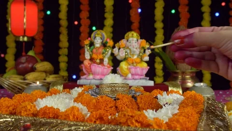 Hands of a young female praying while lighting an oil lamp in a puja Ghar Stock Footage 116247762