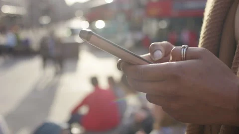 Hands of a young female using her smart phone in the city Stock Footage 252405699
