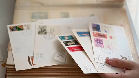 The hands of a young girl are sorting through old envelopes with beautiful co Stock Footage 110419586