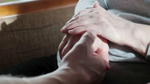 Hands of a young grandson are held by grandmother's wrinkled hands. Care Stock-Footage 123729084