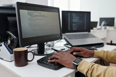 Hands of young male programmer or it-engineer decoding data on computer screen Stock Photos