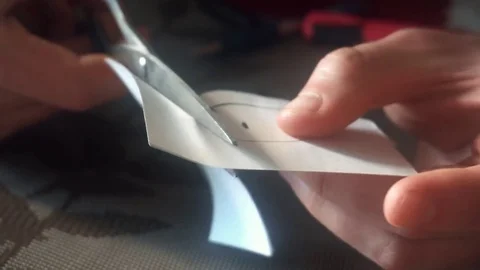 Hands of a young man cut a smiley face out of paper Stock-Footage 75912623