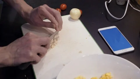 Hands of young man cutting garlic at home kitchen Stock Footage 74160314