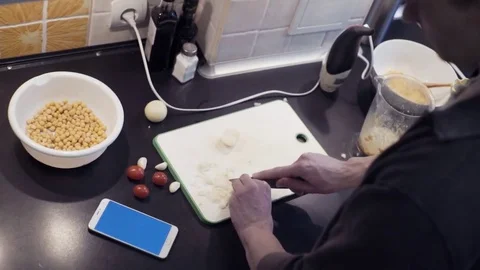 Hands of young man cutting garlic at home kitchen preparing vegetable Stock Footage 74164166