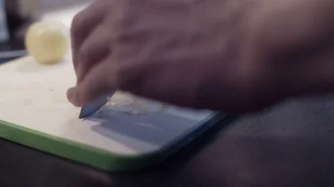 Hands of young man cutting onion at kitchen. Young man preparing vegetable food Stock Footage 74163948