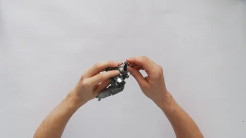 The hands of a young man-engineer holding a micromotor for auto or air racing Stock-Footage 105317574