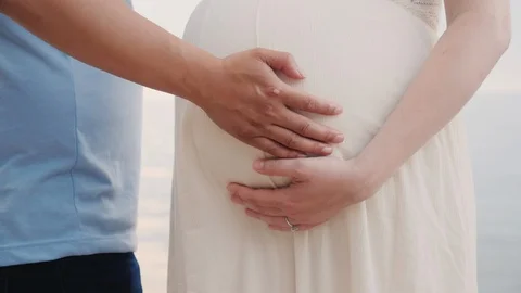Hands of a young man hold hands of his pregnant wife Stock Footage 114498549