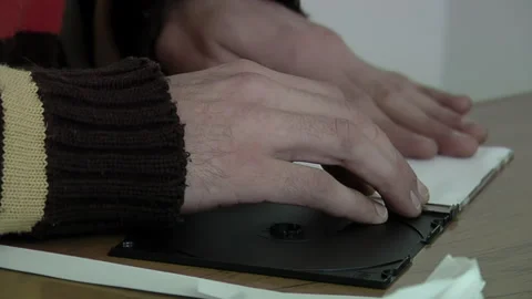 Hands of a Young Man Inserting CD Cover into CD Jewel Case at Home. Close Up. Stock Footage 243918627