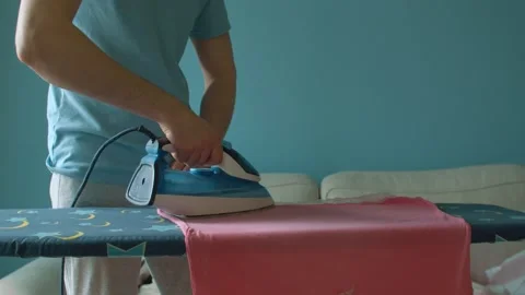 Hands of young man ironing clothes Video stock 130993156