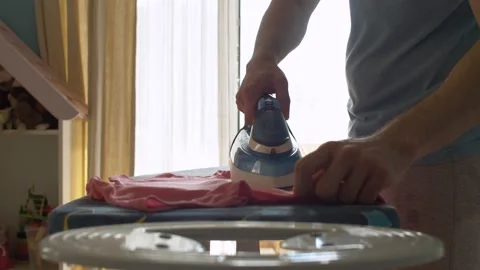 Hands of young man ironing clothes Video stock 130993228