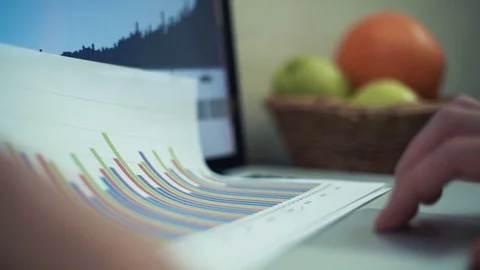 Hands of young man making note with pencil at printed analyzing graphs. Video stock 82934677