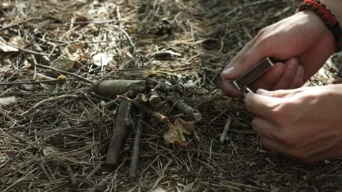 Hands of young man with matches making fire in dry forest ground 動画素材 95176958