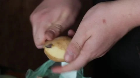 Hands of a young man peeling dirty potatoes with a knife Stock Footage 160964007