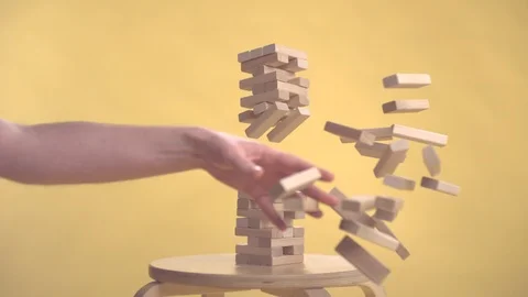 Hands Of Young Man Plays Jenga On Yellow Background slow motion 库存影片 121092147