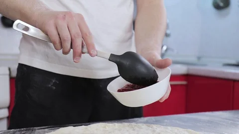 Hands of a young man put and smear tomato paste on pizza dough Stock Footage 127689875