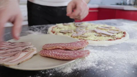 Hands of young man put bacon on pizza dough close up 動画素材 127694638