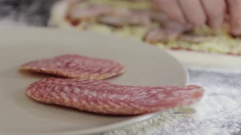 Hands of young man put sausage on pizza dough close up Video stock 127694489