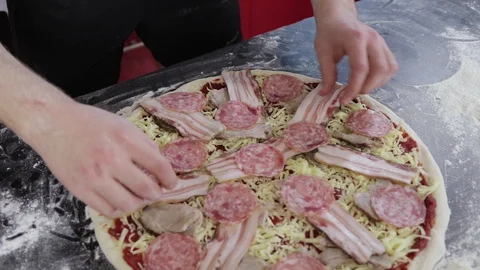 Hands of young man put sausage on pizza dough close up Stock Footage 127694657