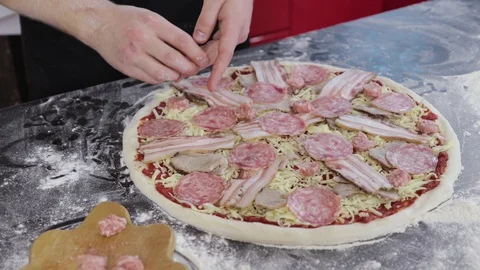 Hands of young man put sausage on pizza dough close up Video stock 127694697