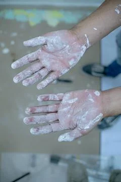 Hands of young man stains with white paint, selective focus Stock Photos