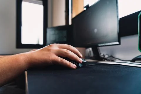 Hands of a young man using the mouse of a laptop computer working as a home Stock Photos