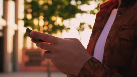Hands of young man using smartphone in the street near shopping mall Stock Footage 243677285