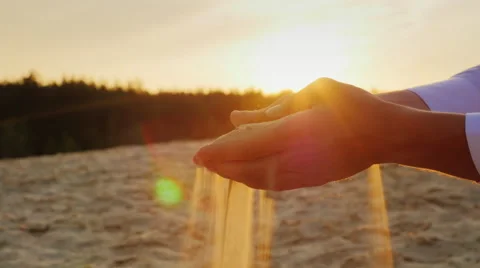 Hands of young men sifted sand through his fingers. current symbol time and Stock Footage 66077384