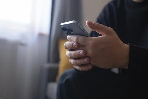 Hands of young person using smartphone indoors close up 스톡 사진