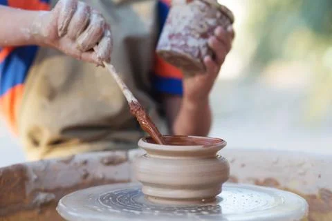 Hands of young potter, creating an earthen jar on the circle, close-up 写真素材