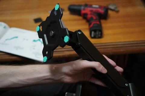 The hands of a young programmer assemble an adjustable stand for mounting a 写真素材