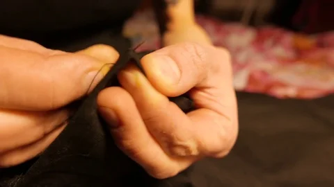 Hands of a young tailor who sews with a needle. 4K UHD Stock Footage 70433692