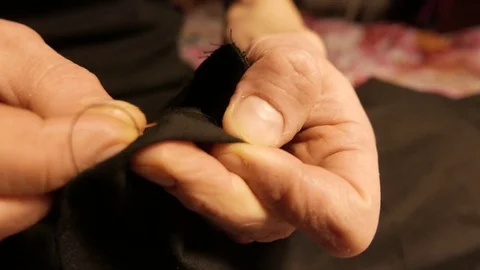 Hands of a young tailor who sews with a needle. 4K UHD Vídeo Stock 70434157