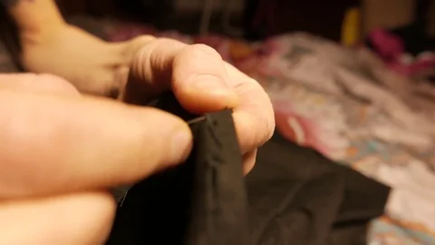 Hands of a young tailor who sews with a needle. 4K UHD Stock Footage 70434236