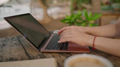 Hands of young woman coding on laptop in outdoor seaside cafe. Female freelancer Stock Footage 236889433