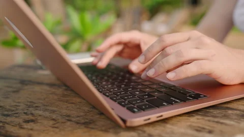 Hands of young woman coding on laptop in outdoor seaside cafe. Female freelancer Stock Footage 238847338