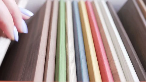 Hands of a young woman sorting through color furniture panels when choosing Video stock 128183231