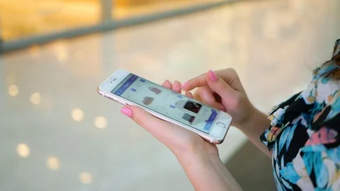 Hands of a young woman using mobile phone in modern shopping mall. Video stock 99351509