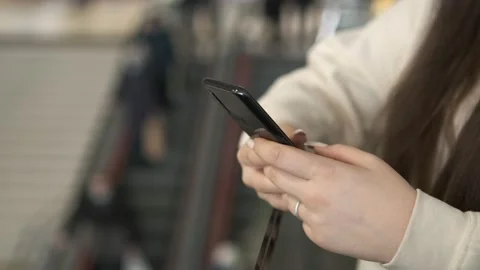 Hands of a young woman using a smartphone in a shopping mall. A young woman is Stock Footage 172559631