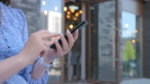 Hands of young woman using smartphone in the street Stock Footage 247453488