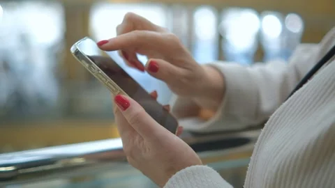 Hands of a young woman using a smartphone in a shopping mall. A young woman is Stock Footage 252168876