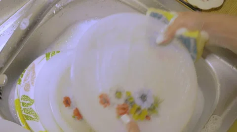 Hands of a young woman washing dishes in the sink Stock Footage