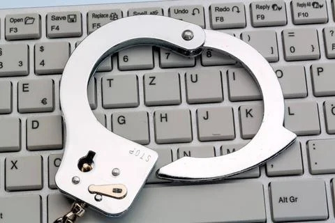  Handschellen auf Computer Tastatur Handschellen liegen auf der Tastatur e... Stock-Fotos