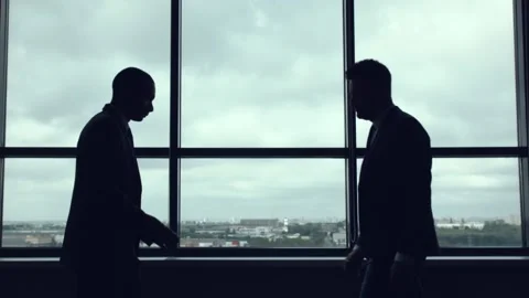 Handshake against the window. Stockbeeldmateriaal 92735478