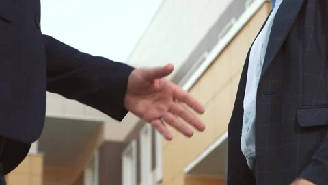 Handshake aimed at achieving goals outlined in company contract against office Stock Footage 254654206