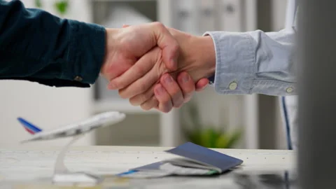Handshake between a travel agent employee and client who bought a ticket to Stock Footage 263901622