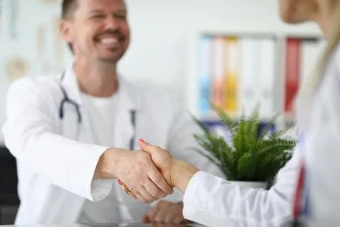 Handshake between two doctors in white coats Stock Photos