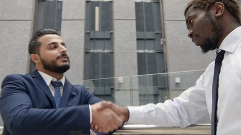 Handshake between two multiethnic businessman Видео 100909895