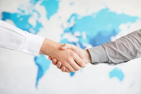 Handshake between two people with world map background Foto stock