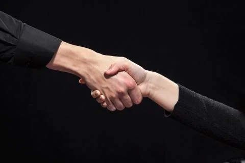 Handshake on a black background. Stock Photos